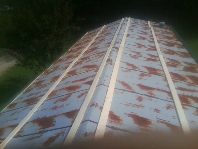 Rusted metal roof panels with new wood purlins before replacement — Storm Damage Roof Repair in West Jefferson by Roofing Brothers