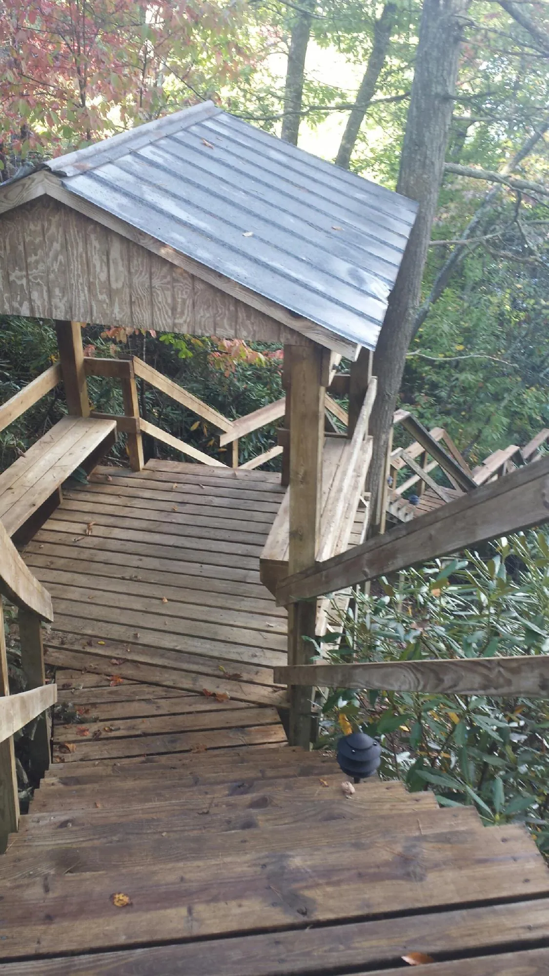 Metal roofed shelter over wooden steps on a wooded walkway — Skylight Repair & Installation work by our crew in West Jefferson